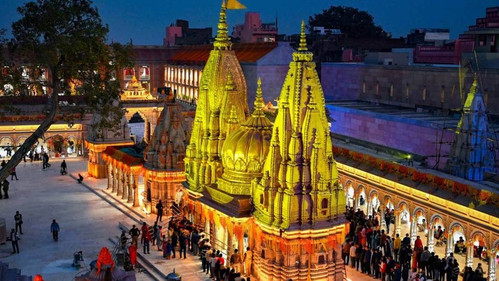 Kashi Vishwanath Temple Varanasi: Illuminated golden spires and ornate shrines crowded with devotees at night, surrounded by festive decorations