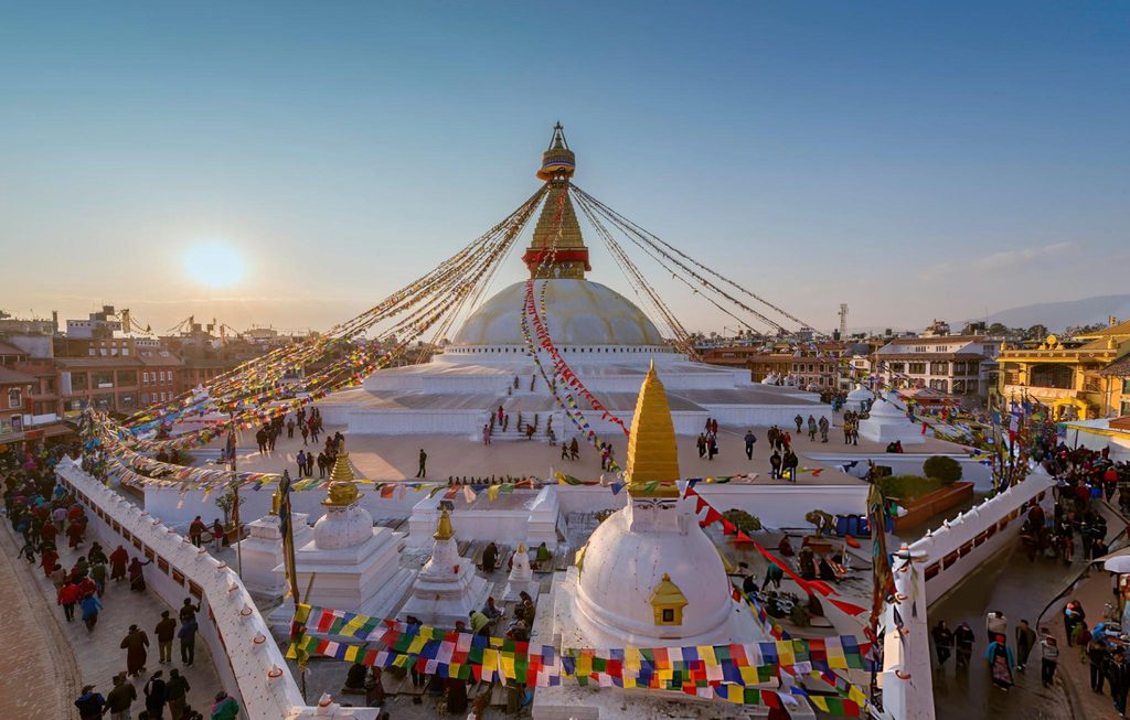 The iconic Boudhanath Stupa in Kathmandu, Nepal, adorned with colorful prayer flags, representing the spiritual heritage of South Asian Gems.