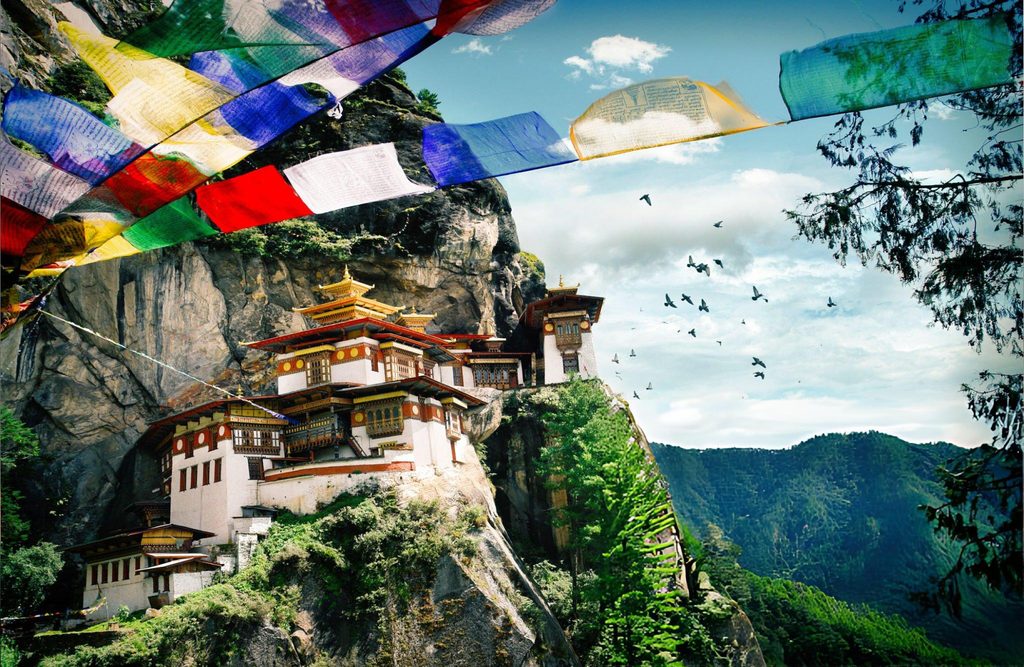 The iconic Tiger’s Nest Monastery in Paro, Bhutan, perched on a cliff amidst stunning natural scenery, a true South Asian Gem.