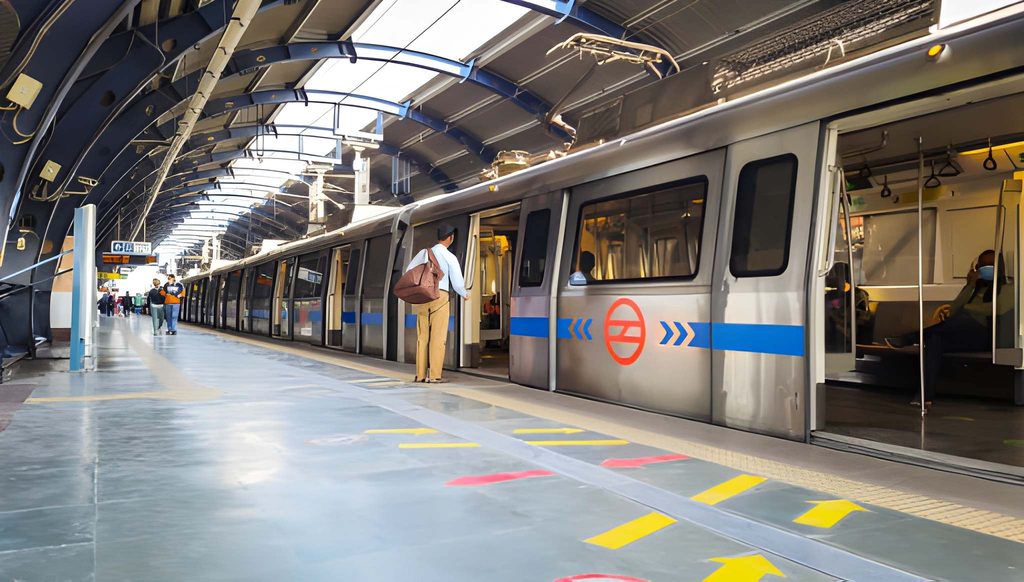 Delhi Metro train stopped at a modern station platform with passengers boarding, showcasing convenient public transportation in Delhi.