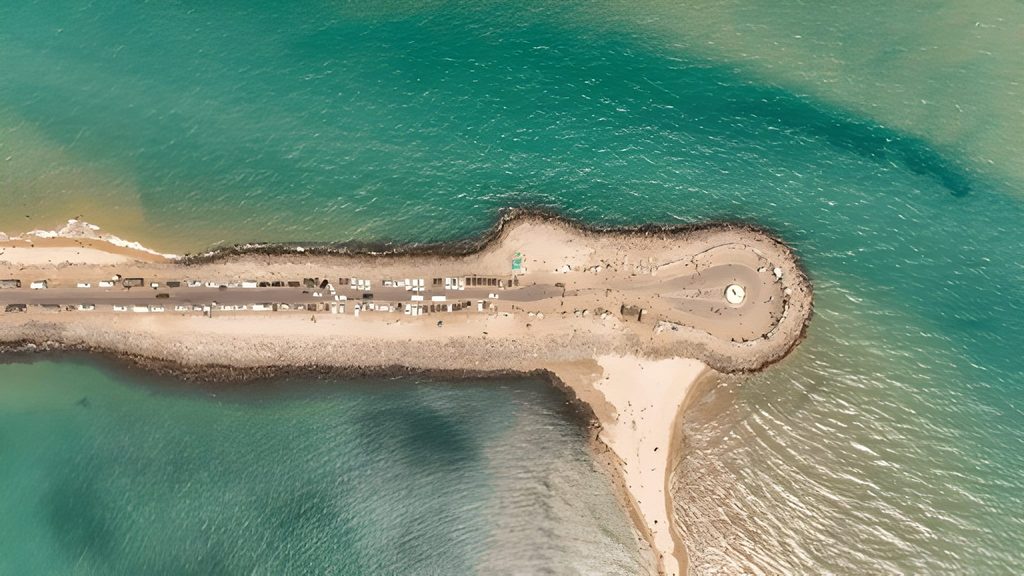 Aerial view of the thin strip of land at Dhanushkodi, Tamil Nadu, separating two shades of turquoise-blue ocean water, representing Underrated Places in India.